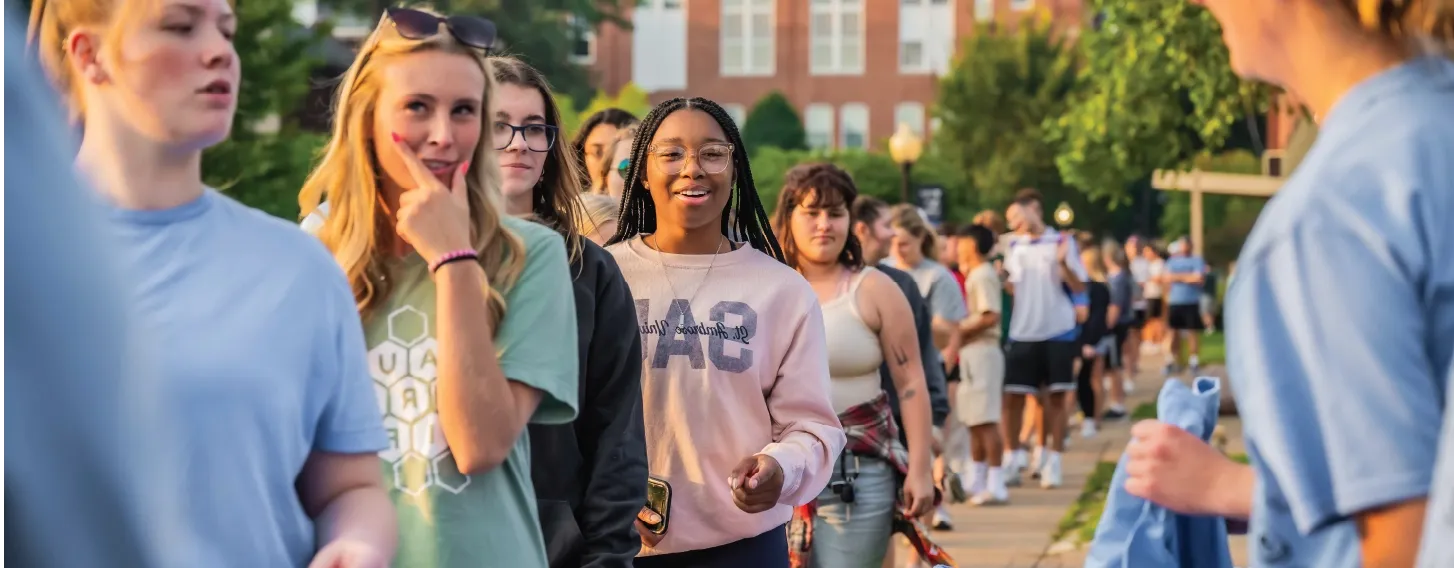 Group of students in line outdoors, smiling.